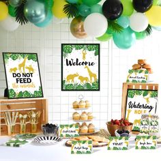 a table topped with desserts and balloons filled with green, yellow and white decorations