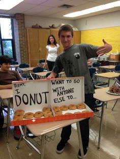 a man standing next to a table with donuts on it