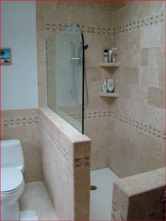 a bathroom with a toilet, shower and shelves in the wall next to the bathtub