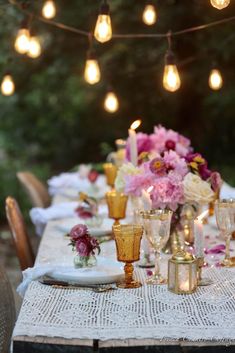 the table is set with flowers and candles