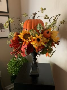 a vase filled with lots of flowers on top of a table