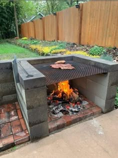 an outdoor fire pit in the middle of a yard with bricks and grilling material