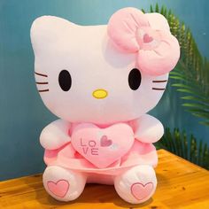 a hello kitty stuffed animal with a heart on it's chest sitting on a table