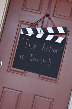 a black and white sign hanging from the side of a door that says, the action is inside