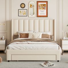 a white bed sitting in a bedroom next to two pictures on the wall above it