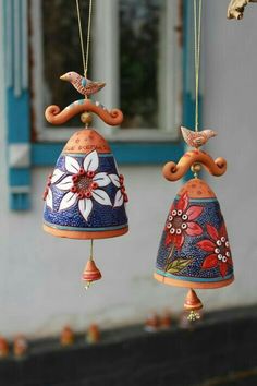 two bells hanging from chains with flowers painted on them