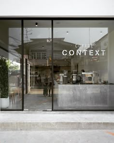 the front window of a coffee shop with people walking in and sitting at their desks