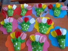 paper flowers are arranged on top of each other in different colors and shapes, sitting on a table