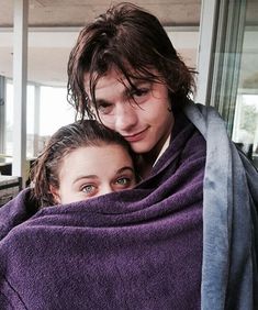 two people wrapped up in purple towels