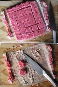 there is a cake that has been cut into squares and placed on a cutting board