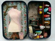 an open suitcase filled with sewing supplies and crafting items on top of a table