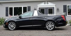 a black car parked in front of a house