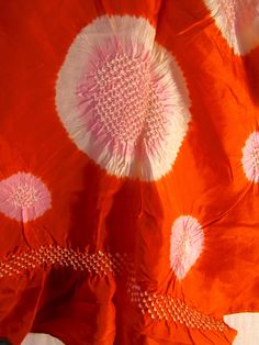 an orange and pink fabric with white circles on it