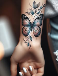 a woman's arm with a butterfly tattoo on the left side of her hand