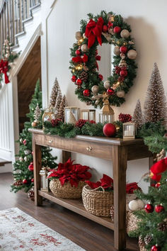 christmas decorations and wreaths are arranged on a table in front of the banister