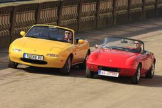 two red and yellow sports cars driving next to each other