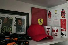 there is a red hat, mugs and other items on the shelf next to each other