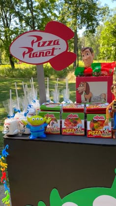 there is a pizza planet stand with many items on the table and in front of it