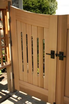 an open wooden gate with metal handles