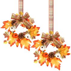 two wreaths hanging from the ceiling with fall leaves and acorns on them