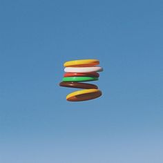 a large hamburger flying through the blue sky