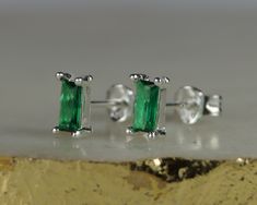 "Sterling Silver Emerald Stud Earrings. This is a pair of really pretty green baguette cut (typically rectangular)  stud earrings. The earrings are a small emerald green glass with stunning colour. Made of sterling silver and green glass, they are not only stunning but really affordable. Comes with sterling silver butterfly backs.  Ideal for first, second, third, or cartilage piercings. Every day or occasional wear. Width of earring: 4mm Length of whole earring: Approx 6mm Please visit our shop Emerald Stud Earrings, First Second Third, Cartilage Piercings, Emerald Earrings Studs, First Second, Cubic Zirconia Earrings, Silver Butterfly, Pretty Green, Zirconia Earrings