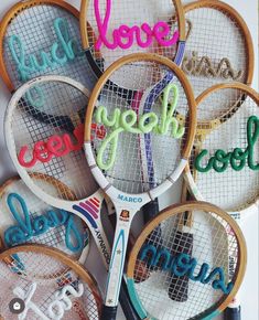 tennis racquets with the word love spelled in different colors on them,