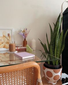 a glass table with a potted plant on it and other items in the background