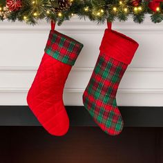 two christmas stockings hanging from a mantel