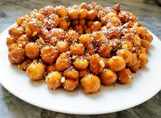 a white plate topped with fried food and sprinkles on top of it