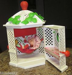 a small doll house with a baby in a hammock on the counter top