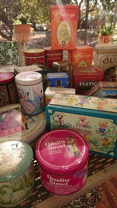 there are many tins on the table with different designs and colors in them,