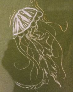 a drawing of a jellyfish on the side of a green shirt with white ink