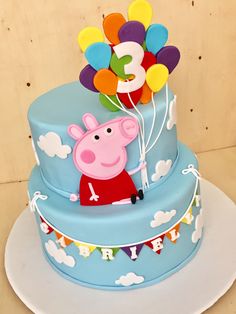 a pep pig birthday cake with balloons on top