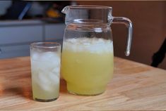 a pitcher and glass filled with ice on a table