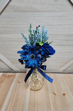 a vase filled with blue flowers on top of a wooden table