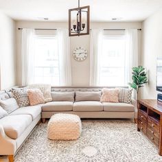 a living room filled with furniture and a large clock mounted to the wall above it