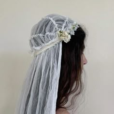 a woman wearing a veil with flowers on it