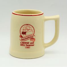 a coffee mug with the international cheese and deli seminar logo on it's side