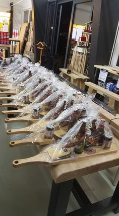 several wooden paddles are lined up on a table in a store with plastic bags over them