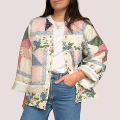 a woman is wearing a jacket with patches and flowers on it, she has her hands in her pockets