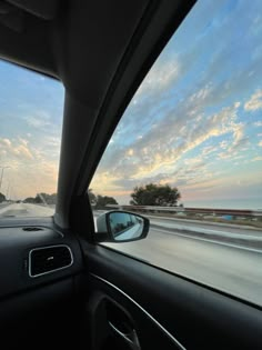 the sun is setting over the ocean as seen from inside a car's dashboard