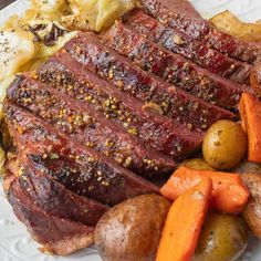 a white plate topped with meat, potatoes and carrots