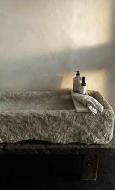 a stone sink with two soap dispensers sitting on it's side