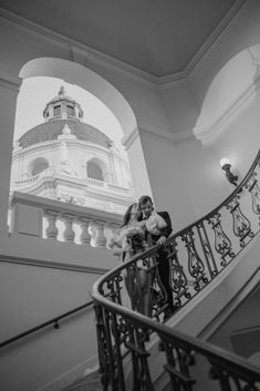 a man and woman standing on top of a stair case