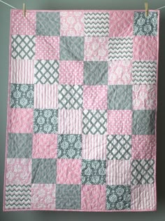 a pink and gray quilt hanging on a clothes line