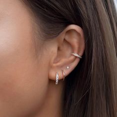 a close up of a woman's ear with two diamond studs on it