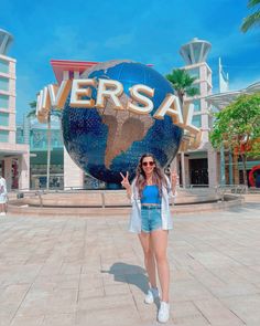 a woman standing in front of a large sign that says universal