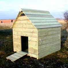 a small wooden dog house in the middle of a field with no one around it