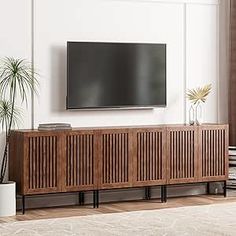 a flat screen tv mounted to the side of a wooden cabinet in a living room